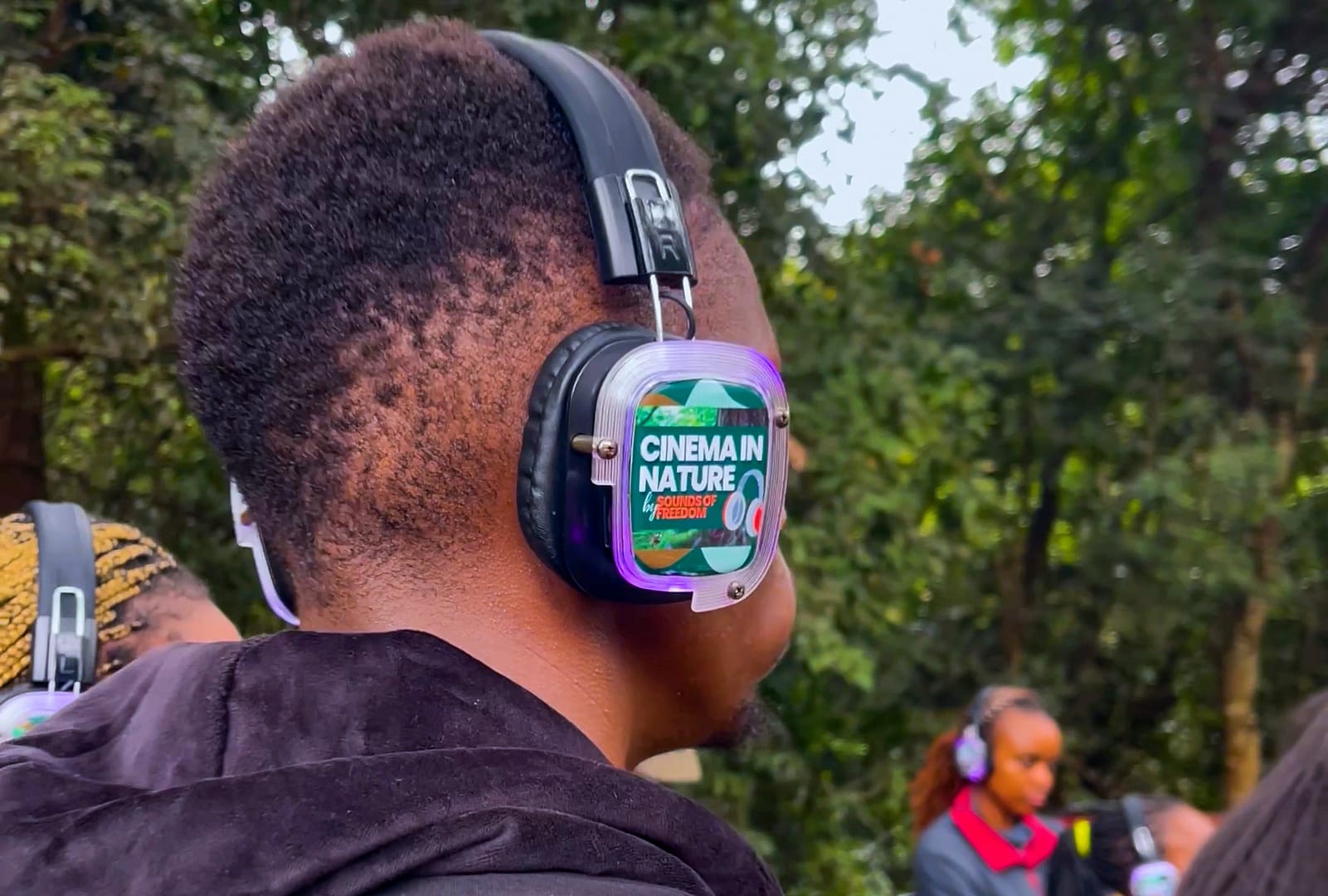 A participant listening to a dramatized audio story of Kenya's Mau Mau resistance while walking along curated trails in Karura Forest, Nairobi, Kenya. Photo: Immanuel Muasya, bird story agency